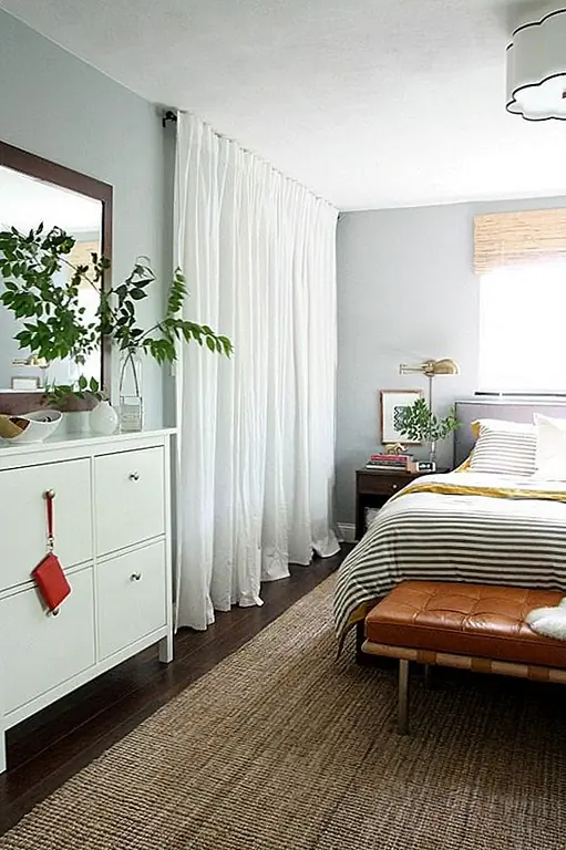 Вы не могли сказать, что эти белые занавески не закрывают окно, а на самом деле шкаф, просто глядя на пространство издалека. Это довольно забавная деталь дизайна. Кроме того, занавески делают спальную зону более теплой и уютной. Мы нашли этот дизайн на сборке. Из шкафа нет мебели, и все внутри легко доступно. Вы даже можете оставить занавески открытыми, если хотите. Скрыть беспорядок тоже довольно легко.