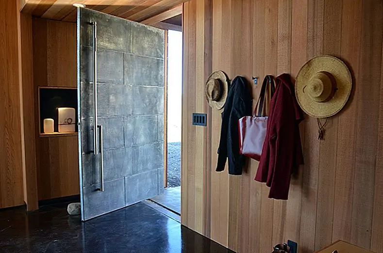 Поворотные двери могут иметь различные функциональные возможности. Они могут поворачиваться в центре или иметь асимметричную систему, которая позволяет им открываться больше с одной стороны. Такая идея полезна, если дверь не особенно велика, и вы хотите сделать ее максимально функциональной, не переключаясь на другой тип двери. Отличным примером в этом случае является дом, спроектированный Johnston Architects в Вашингтоне.