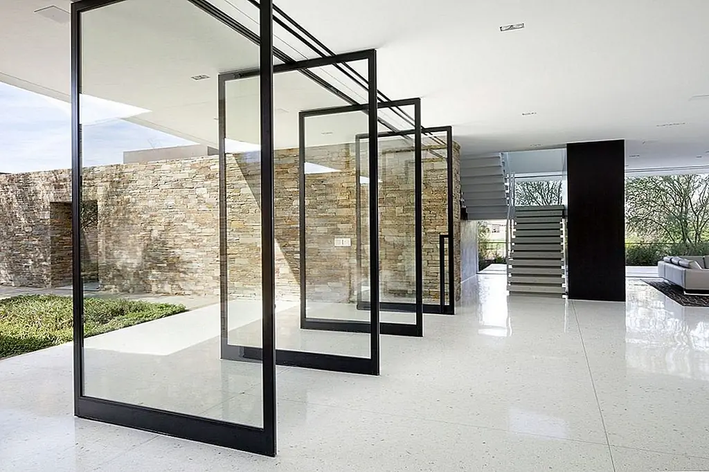 Там всегда сила в количестве и, даже если это место жительства не имеет одну большую дверь поворота, он знает, как сделать большую часть этой функции. Архитектура XTEN предоставила этому дому всю стену поворотных дверей. Двери сделаны из прозрачного стекла и имеют гладкие черные рамки. Их роль заключается в том, чтобы открыть внутренние жилые помещения в окрестностях и вывести на улицу. Две другие стены имеют раздвижные стеклянные двери, и это позволяет полностью открыть первый этаж для пейзажа.