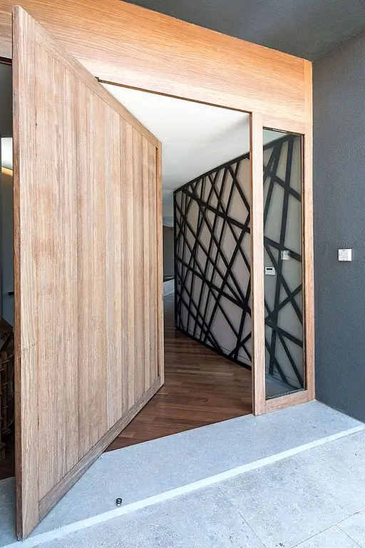 Резиденция, столь же впечатляющая, как и Edge House, нуждается в отличительной входной двери, чтобы соответствовать ее характеру. Участок, на котором дом был построен Studio Omerta, придает ему видный вид, а огромная поворотная дверь у входа была спроектирована в соответствии с общей пропорцией резиденции. Дверь выполнена из массивной древесины с прозрачной стеклянной боковой панелью.