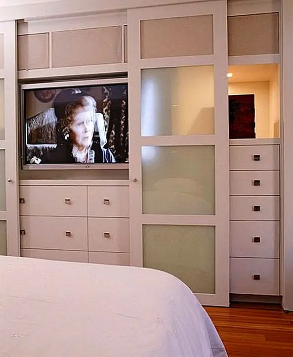 Но раздвижные двери часто показывают больше, чем просто полки и отделения, заполненные одеждой и аксессуарами. Этот гардероб, например, скрывает секрет. За раздвижными дверями есть телевизор, и они играют только роль скрытия телевизора, когда это не нужно. Таким образом, декор становится более простым и воздушным. Так что, несмотря на то, что раздвижные двери не имеют возможности скрывать содержимое гардероба, они по-прежнему прекрасно сочетаются с декором.