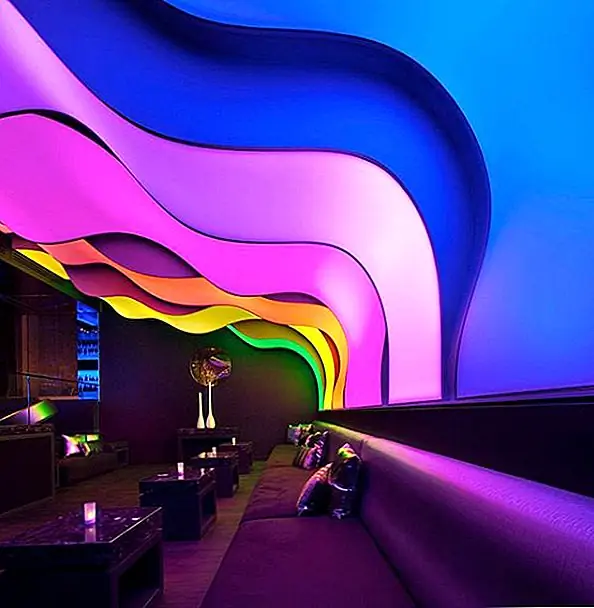 Массивный светильник соединяет потолок и стены. Он напоминает рябь или ленты и имеет волнообразные линии, которые вместе с цветами создают завораживающий визуальный эффект. В дополнение к этой впечатляющей функции, в гостиной также есть длинная стена из серебряных бусинок. Когда свет отражается на этой стене, изменяющиеся цвета создают потрясающий эффект. Наилучшая часть об этом огромном светильнике - то, что он может идти от смелой и яркой до успокаивающей и расслабляющей. Это может изменить настроение в мгновение ока.