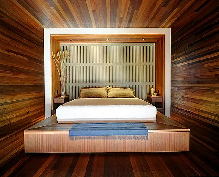 Кровать здесь сидит на платформе, и она встроена в нишу с индивидуальной кожаной стеной. Стены, потолок и пол покрыты деревом, и эта симметрия позволяет выделить нишу, а остальная часть комнаты - фон. {Найден на Bates Masi Architects}.