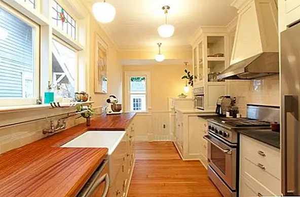 Здесь также есть традиционная кухня, но с совершенно другим дизайном и декором. Эта кухня, помимо деревянной столешницы, имеет красивый деревянный пол с очень похожим цветом и отделкой. Сочетает себя с бледными бежевыми стенами и мебелью, имеющими сходный цвет, эти элементы создают теплую и уютную атмосферу.