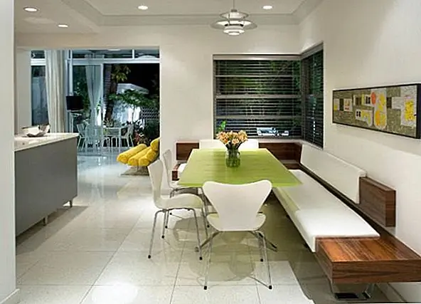 Эта кухня довольно просторная. Он соединен со столовой, но две области разделены стеной. Сама кухня очень большая, а также обеденная зона с минималистской L-образной скамейкой и стильные стулья, расположенные вокруг красивого зеленого стола. Остальная часть декора проста и ярка и имеет сильные современные влияния.