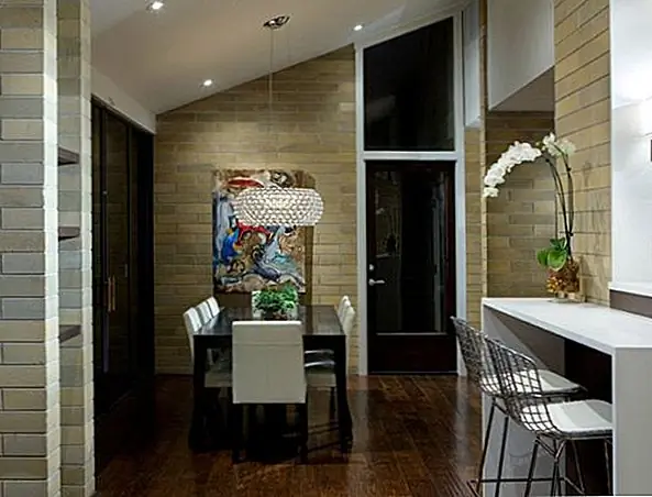 В конце мы покажем вам еще одну красивую современную кухню середины века. Этот был переделан и теперь имеет более современный интерьер. Несмотря на то, что он довольно маленький, он имеет элегантный интерьер. В нем также есть небольшой завтрак или бар и столовая с прекрасной люстрой, подвешенной над столом. Кирпичные стены - замечательная деталь акцента.