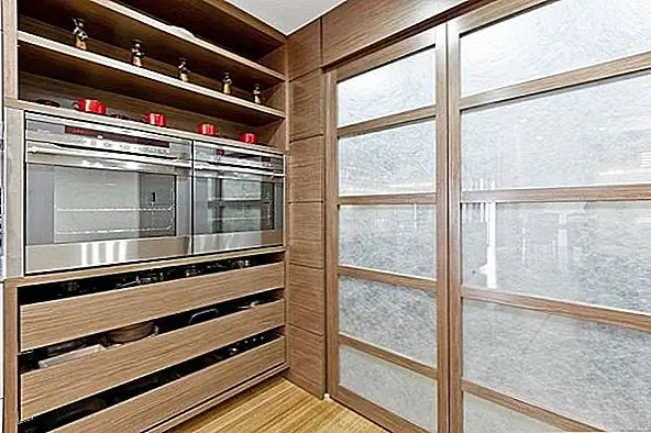 На кухне есть кладовка дворецкого в задней части, где находится холодильник и место для хранения пищи. Кухня также имеет простые шкафы с чистыми линиями и утопленными ручками. Дизайнер использовал натуральные материалы, и это создает спокойный и почти дзен-эффект. Японское влияние явно сильное, но в хорошем смысле. Это просто, функционально и стильно одновременно.