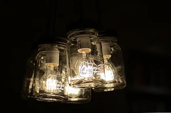 Последний проект, который мы покажем вам, - это также люстра, но эта сделана с использованием банки Мейсона. Банки прозрачны, поэтому свет яркий, но он также тонкий и приятный. Банки - подвески, и они соединены с лампами накаливания для приятного винтажного вида и очаровательного дизайна. Комната будет чувствовать себя очень уютно и комфортно с такой люстрой.