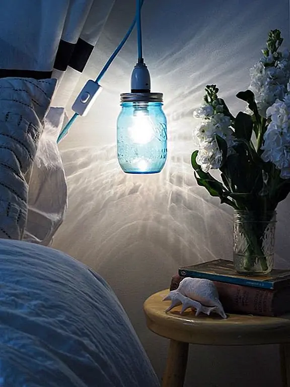 Эта банка имеет приятный синий оттенок, но вы можете выбрать любой тип, который вы хотите. Сначала вы присоедините лампочку к крышке. Проследите вокруг гнезда и сделайте крошечные отверстия с помощью гвоздя и молота вокруг него. Затем крышку следует хорошо вставить в крышку. Вверните лампу в розетку и банку в крышку. {Найдено на abeachcottage}.