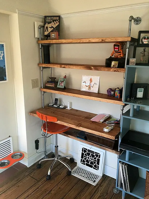 Если вам нравится мебель в промышленном стиле с намеком на деревенский шарм, ознакомьтесь с этим стеллажом, представленным на Etsy. Он выполнен из металлических труб и регенерированной древесины, а одна из самых низких полок на самом деле шире и предназначена для использования в качестве встроенного стола. Там есть еще одна полка, и она узкая и идеально подходит для хранения канцелярских принадлежностей, книг и других вещей, точно так же, как полки наверху.