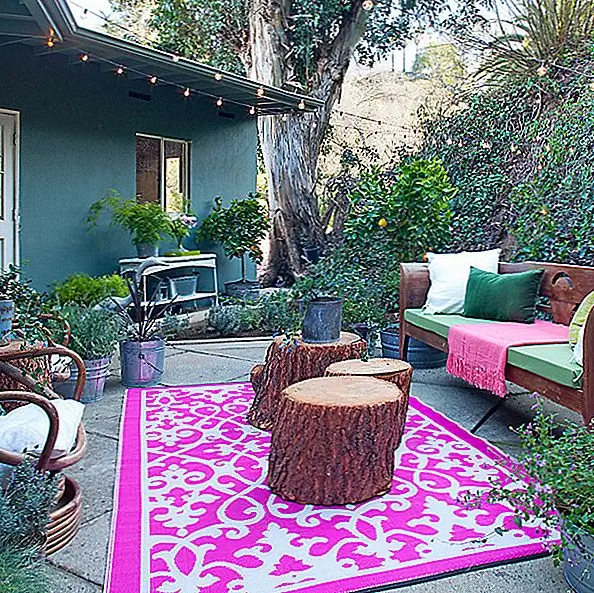 Этот дизайн внутреннего дворика может быть не самым ярким, но добавление коврика делает его гораздо более яркой областью, в то же время очень уютной и гостеприимной. И мы любим всю зелень вокруг этого места!