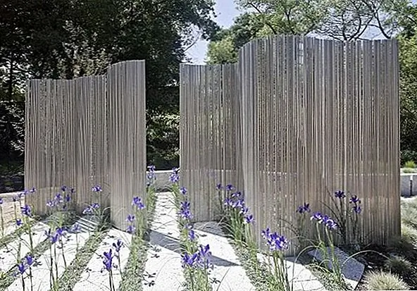 Хотя металл - это еще один материал, который традиционно используется в фехтовании, обычно в виде чугуна, этот экран конфиденциальности использует его по-другому. Металлическая труба установлена в бетоне в волнообразном узоре, чтобы создать этот смелый вид.