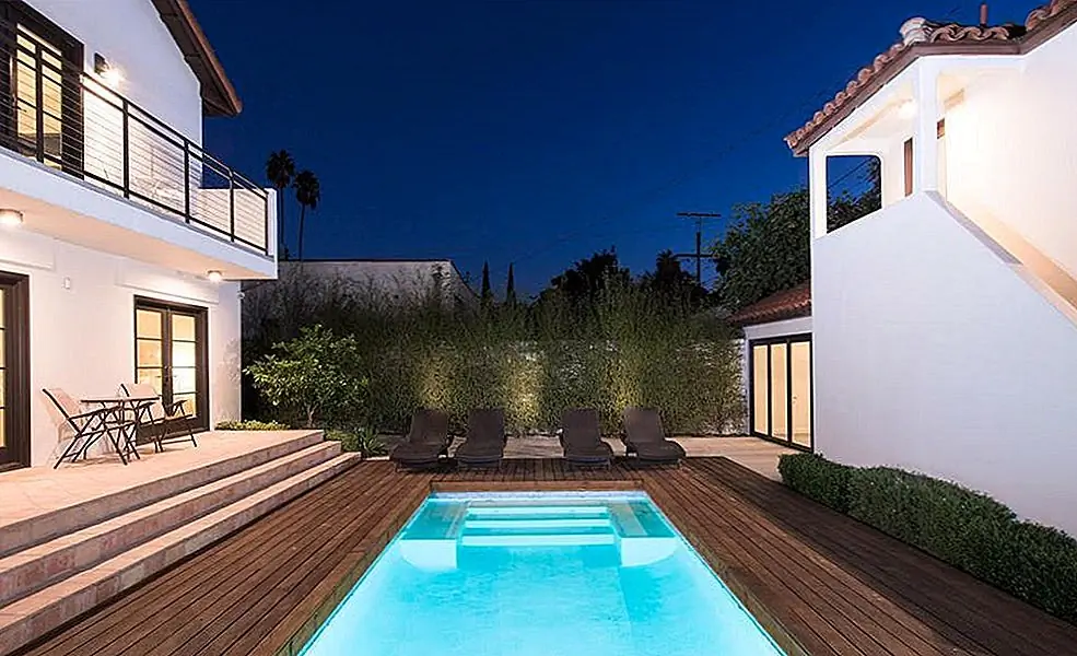 Бассейн разделяют главный дом (справа) и связанное гостевое бунгало и дом с кабаной (слева).