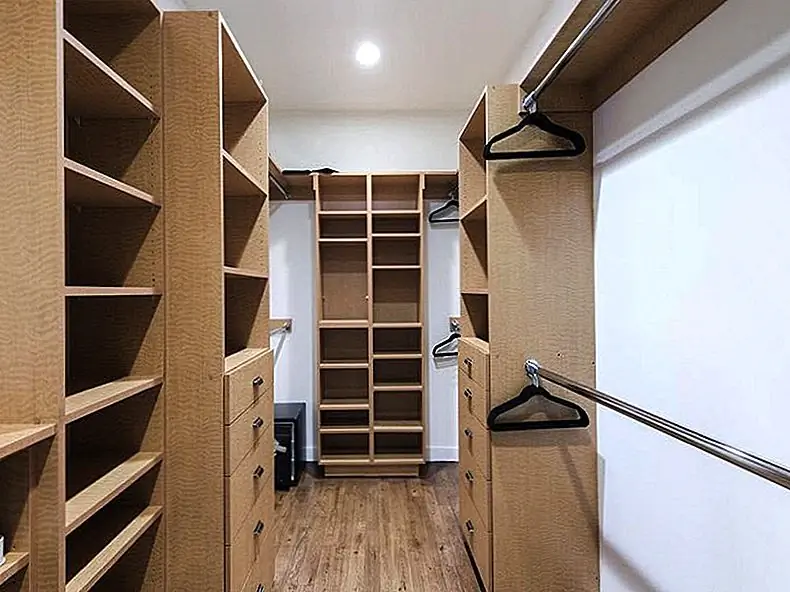 Большой встроенный шкаф для главной спальни предлагает достаточно места для одежды и обуви.