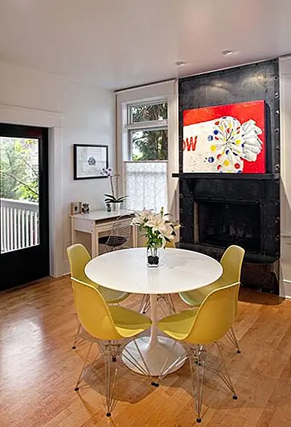 Это еще одна столовая. На этот раз декор эклектичен и более яркий. Желтые стулья Eames расположены вокруг белого круглого стола, и они делают приятный переход между нейтральными и смелыми элементами. Несмотря на то, что они единственные желтые куски в комнате, они не сталкиваются с другими красочными фигурами.