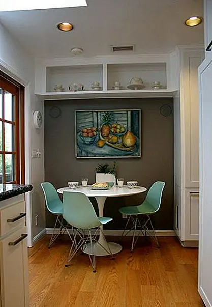 И вот еще одна кухня, на этот раз с эклектичным интерьером. Он разделен на рабочее место для приготовления блюд и приглашающей столовой. Этот район организован возле стены с акцентом и имеет белый круглый стол и три бледно-бирюзовых боковых стула Eames. На стене также есть картина с подобной цветовой палитрой.