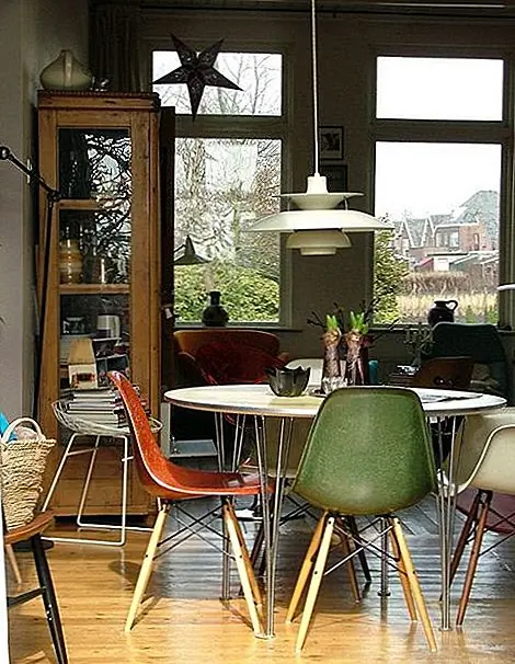 Это оформление винтажной столовой. Цветовая палитра очень красивая, а также разнообразие текстур. Там также хороший баланс света и темных областей, и атмосфера кажется очень уютной и привлекательной. В декоре есть классический круглый стол с белой крышей и металлической основой, окруженный боковыми стульями Эймса, с деревянными ногами.